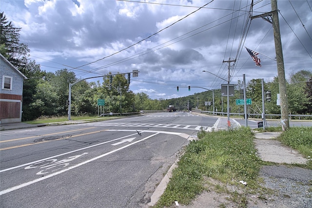 view of street with sidewalks, curbs, traffic lights, and street lighting