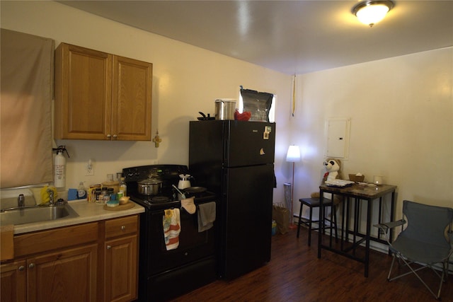 kitchen featuring electric panel, dark wood-type flooring, a sink, and black appliances