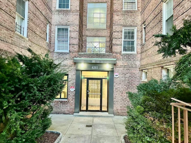 view of exterior entry featuring brick siding