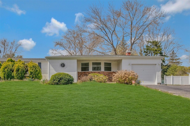 single story home with a garage, a front yard, driveway, and fence