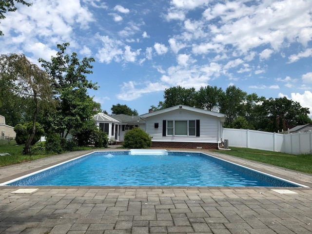 outdoor pool with a patio and fence