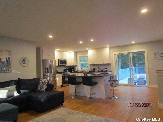 living area with recessed lighting and light wood finished floors