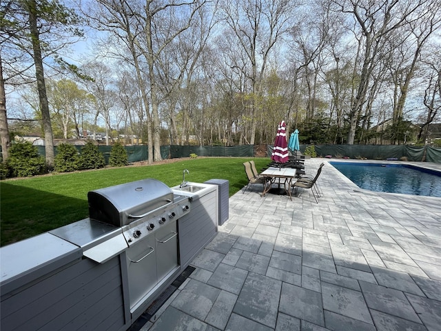 view of patio with a sink, a fenced in pool, a fenced backyard, area for grilling, and outdoor dining space