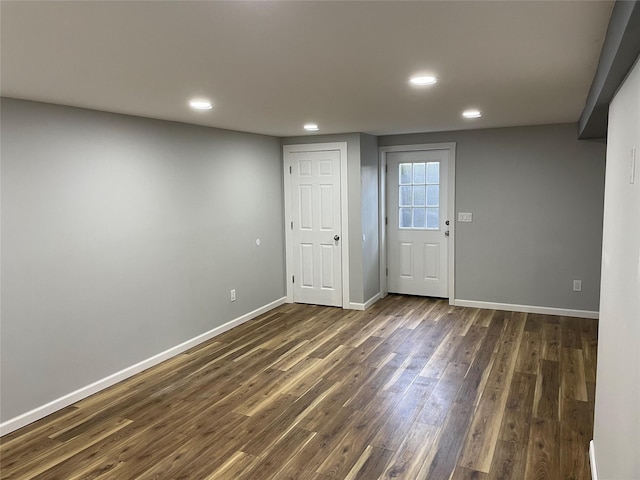 empty room featuring recessed lighting, dark wood-style flooring, and baseboards