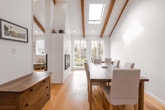 35 Turtle Cove Ln, Huntington, NY 11743 - dining area with a brick fireplace, light wood finished floors, a skylight, and recessed lighting