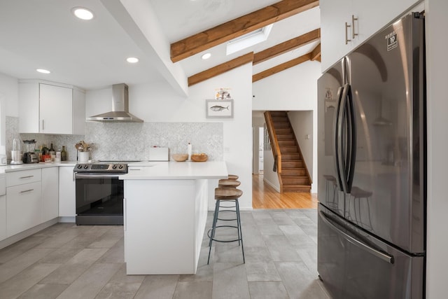 35 Turtle Cove Ln, Huntington, NY 11743 - kitchen featuring appliances with stainless steel finishes, wall chimney exhaust hood, a kitchen bar, a peninsula, and backsplash