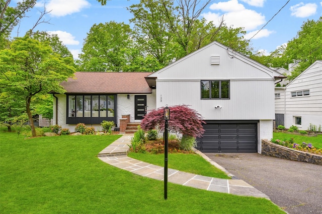 134 Highland Rd, Scarsdale, NY 10583 - split level home with an attached garage, driveway, a front lawn, and brick siding