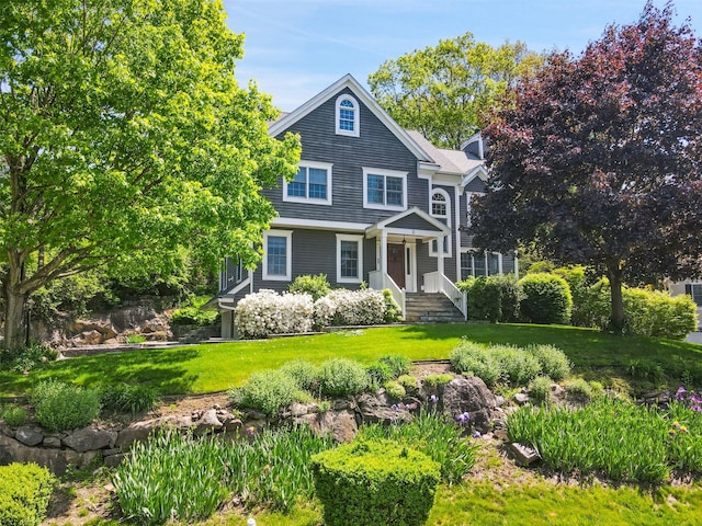 shingle-style home featuring a front lawn and a chimney