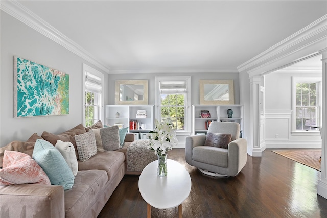 living area with healthy amount of natural light, ornamental molding, dark wood-style flooring, and ornate columns