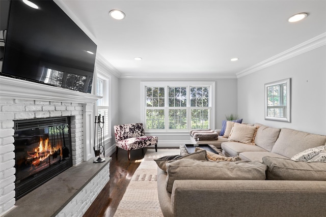living room featuring ornamental molding, dark wood-type flooring, plenty of natural light, a fireplace, and recessed lighting