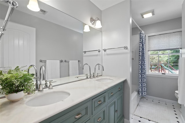 bathroom with toilet, double vanity, and shower / tub combo