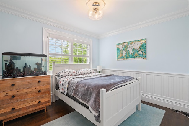 bedroom featuring crown molding, dark wood-style floors, and a wainscoted wall