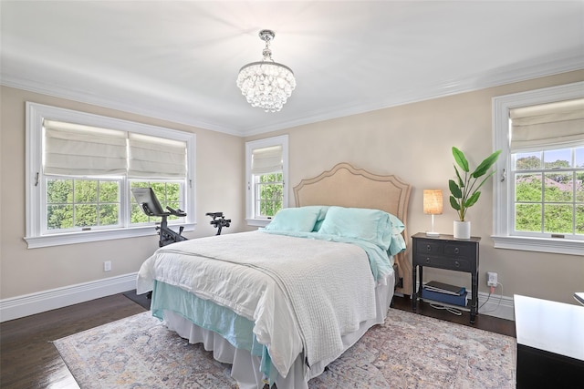 bedroom featuring a chandelier, baseboards, crown molding, and wood finished floors