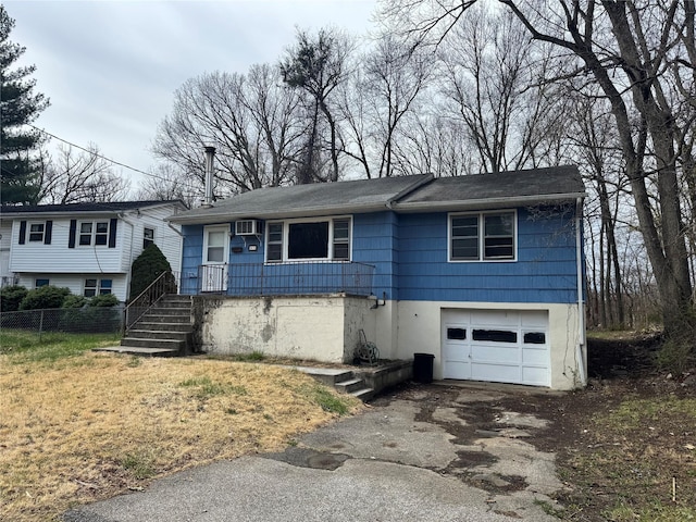 view of front of property featuring an attached garage, aphalt driveway, and fence
