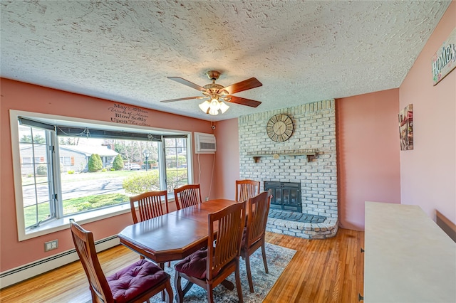 dining room featuring a textured ceiling, a healthy amount of sunlight, a ceiling fan, and a baseboard heating unit