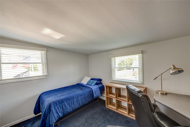 bedroom featuring dark colored carpet and baseboards