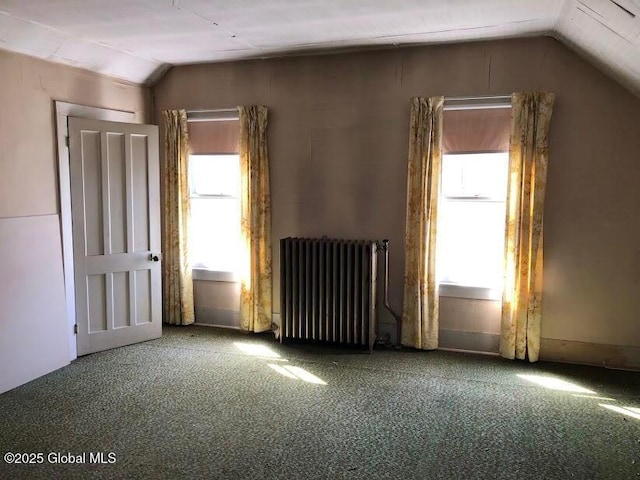 interior space with carpet, lofted ceiling, and radiator heating unit