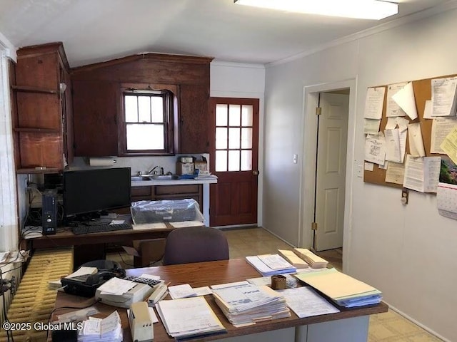 office space with baseboards, ornamental molding, light floors, and lofted ceiling