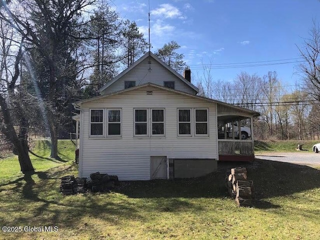 view of side of property with a yard and a chimney