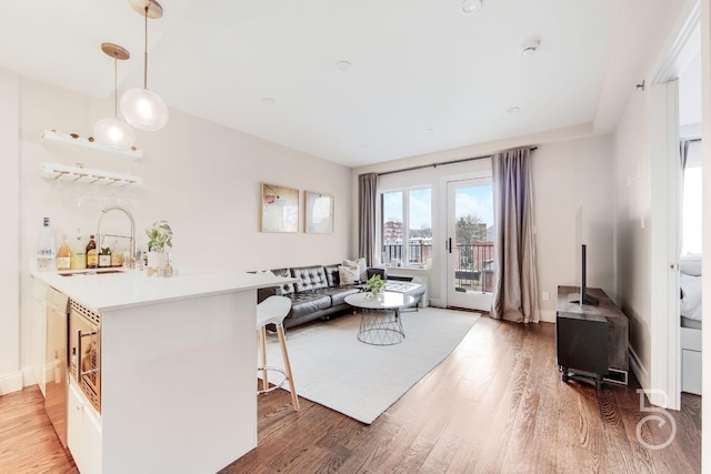 living area with wet bar and light wood-style flooring