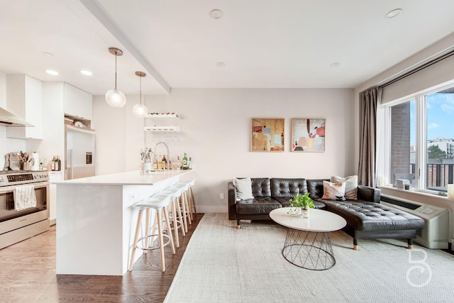 living area with baseboards, recessed lighting, and wood finished floors