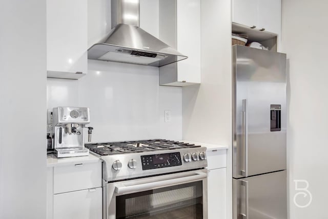 kitchen with wall chimney range hood, appliances with stainless steel finishes, modern cabinets, light countertops, and white cabinets