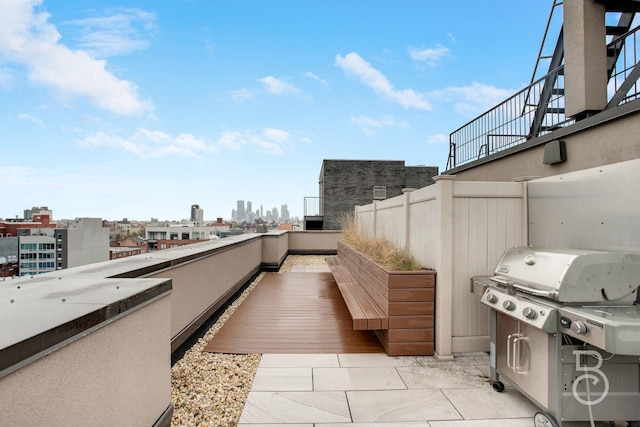 view of patio featuring a view of city, stairs, and a grill