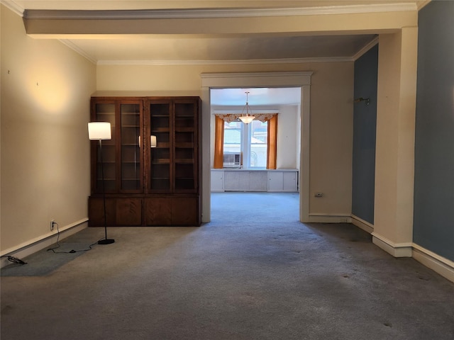 carpeted spare room with baseboards, ornamental molding, and cooling unit