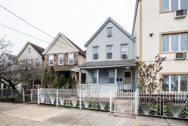 101-14 95th St, Ozone Park, NY 11416 - view of front facade featuring a porch, a fenced front yard, a gate, and cooling unit