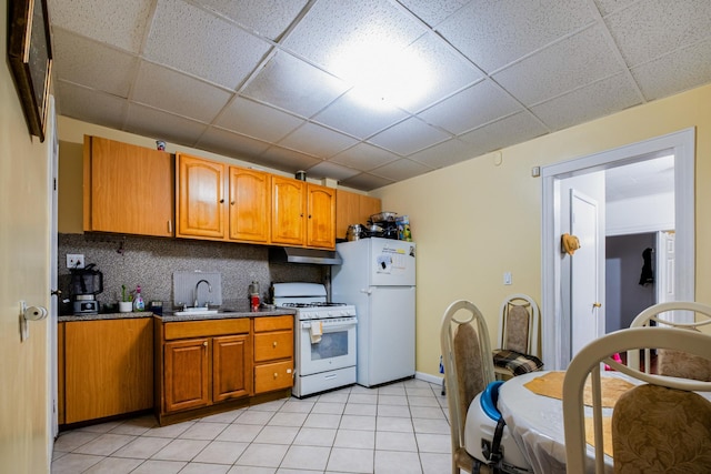 101-14 95th St, Ozone Park, NY 11416 - kitchen featuring white appliances, under cabinet range hood, a sink, light tile patterned flooring, and a paneled ceiling