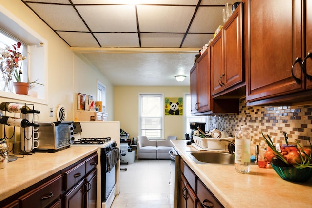 101-14 95th St, Ozone Park, NY 11416 - kitchen featuring gas stove, light countertops, tasteful backsplash, stainless steel dishwasher, and a drop ceiling