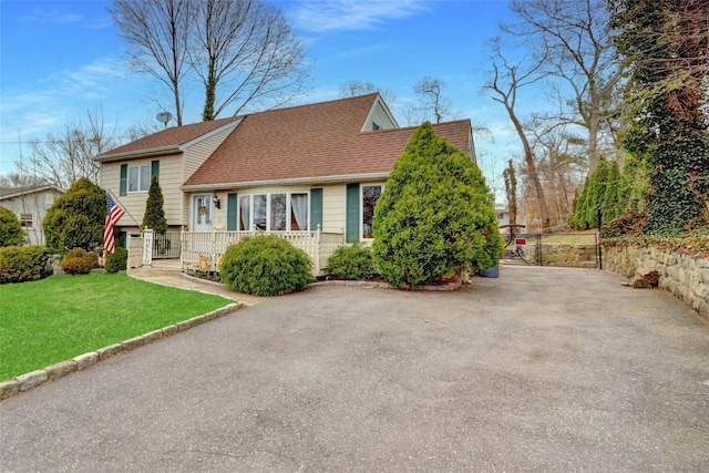 tri-level home with a shingled roof and a front lawn