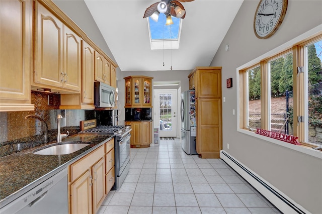 kitchen with vaulted ceiling with skylight, a baseboard heating unit, a sink, and stainless steel appliances