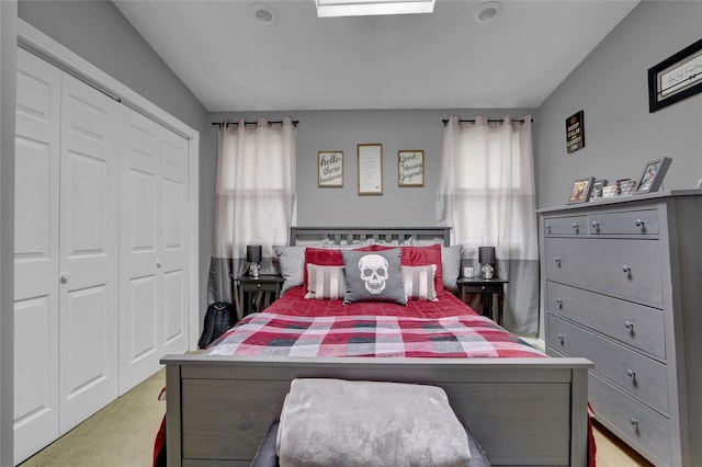 bedroom with a closet, light colored carpet, multiple windows, and vaulted ceiling