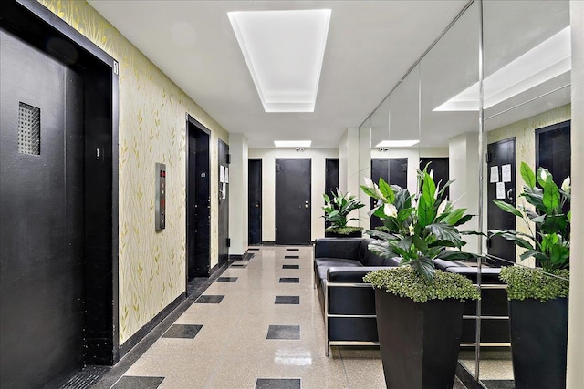 hall with elevator and baseboards