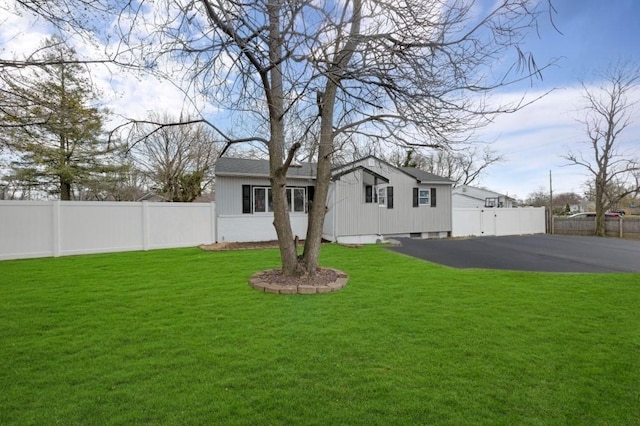 view of front of house featuring fence and a front lawn