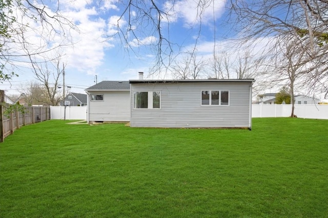 back of property with a yard and a fenced backyard