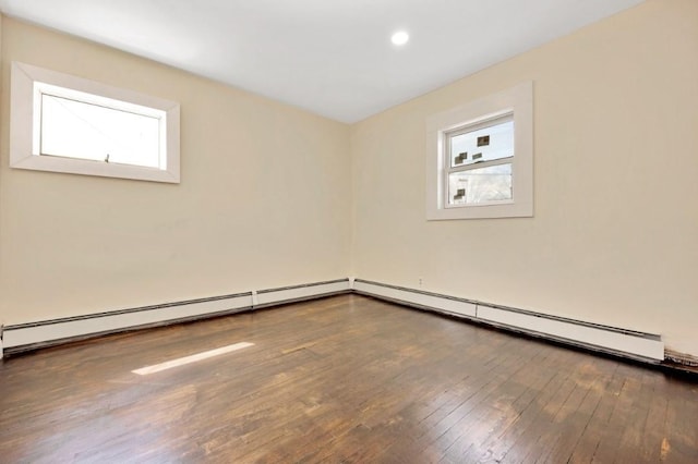 empty room featuring recessed lighting, plenty of natural light, a baseboard heating unit, and hardwood / wood-style floors