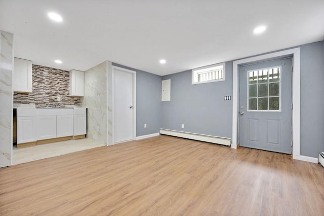 unfurnished living room with recessed lighting, baseboard heating, baseboards, and light wood-style flooring