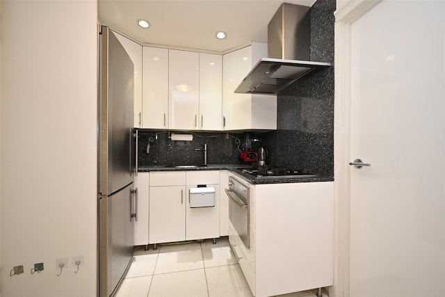 99-60 63rd Rd Unit 9Y, Rego Park, NY 11374 - kitchen featuring light tile patterned floors, white cabinets, oven, wall chimney range hood, and backsplash