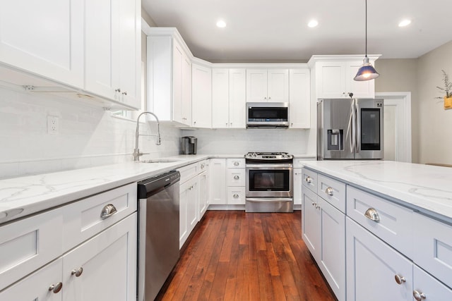 kitchen featuring a sink, decorative backsplash, white cabinets, and stainless steel appliances
