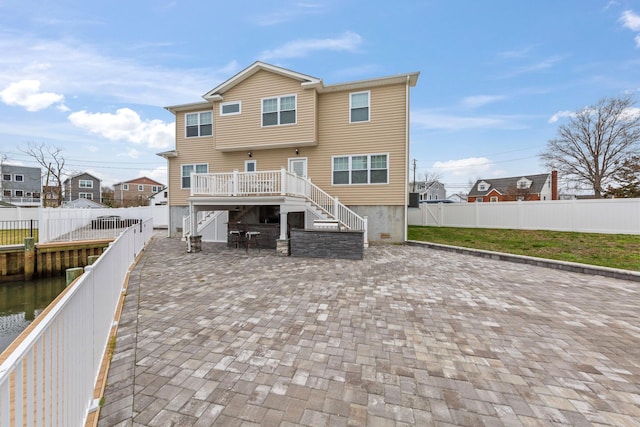 rear view of property featuring a deck, a patio area, a fenced backyard, stairway, and a residential view