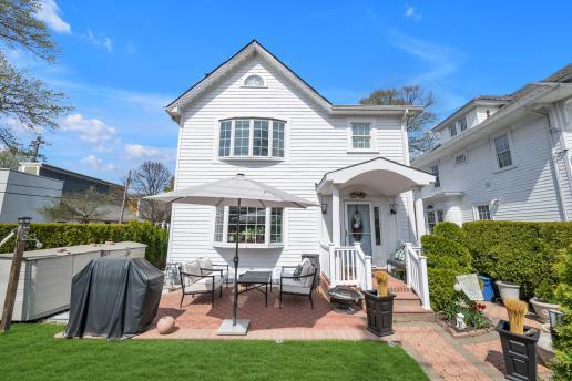 rear view of house with a lawn and a patio