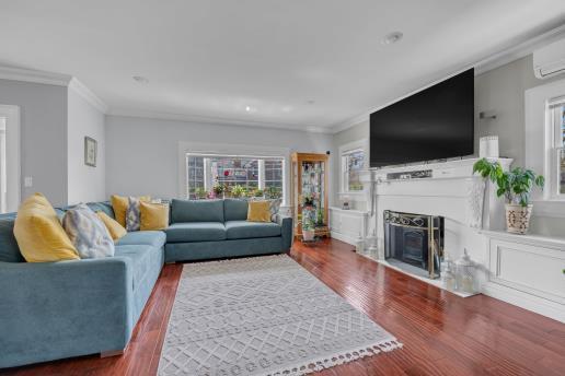 living room with plenty of natural light, wood finished floors, and ornamental molding