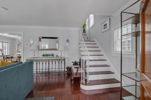 stairway featuring wood finished floors and crown molding