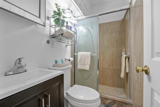 full bath with a shower stall, toilet, and vanity