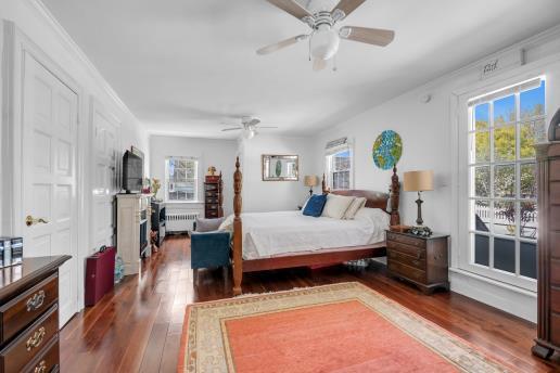 bedroom with a ceiling fan, dark wood finished floors, and radiator