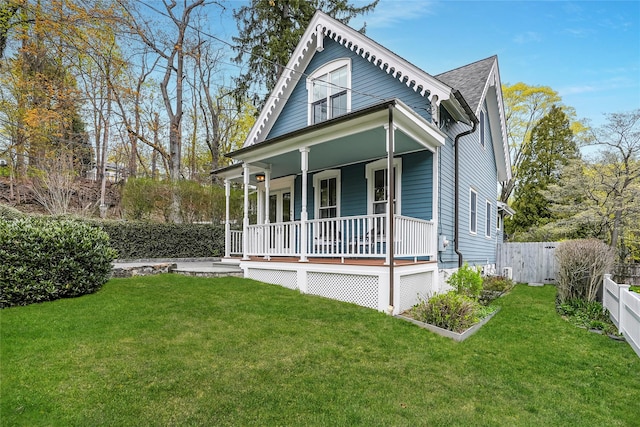 bungalow-style house with a porch, fence, and a front lawn