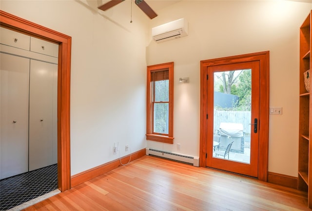 entryway with light wood-style floors, baseboards, ceiling fan, an AC wall unit, and a baseboard radiator