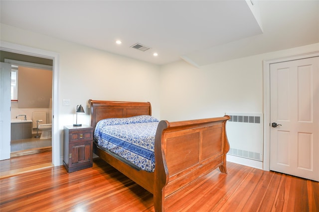 bedroom with visible vents, recessed lighting, radiator heating unit, and light wood-type flooring
